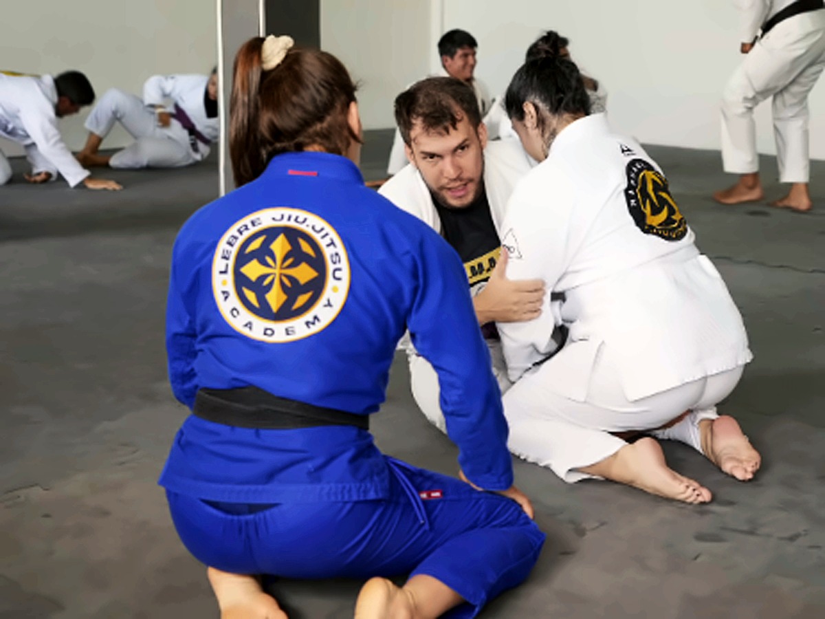 Dupla treinando de kimono azul no tatame